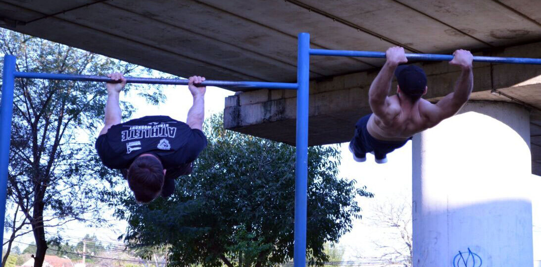 Atleta Elias e Bruno realizando barra juntos.