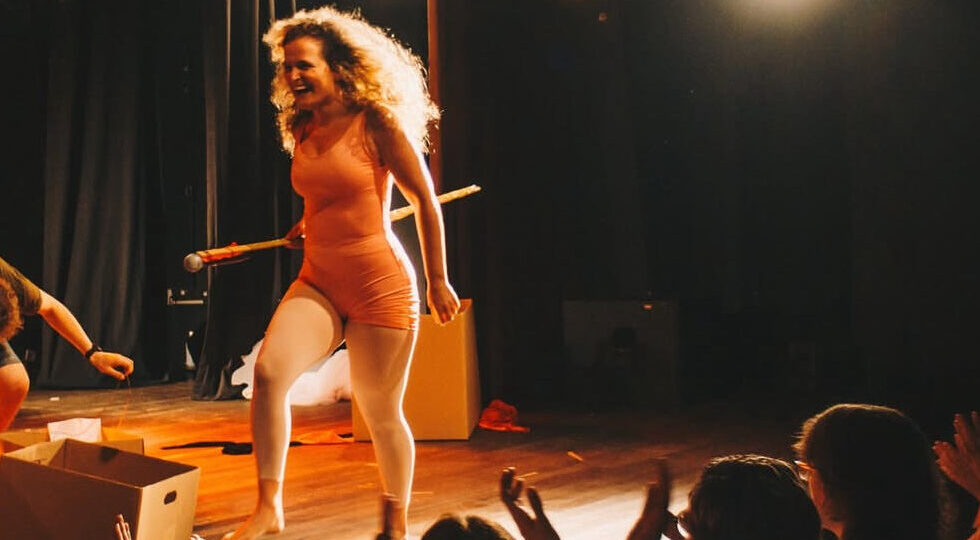 Foto de Aline Marques no palco, apresentando o espetáculo Esculhambada.